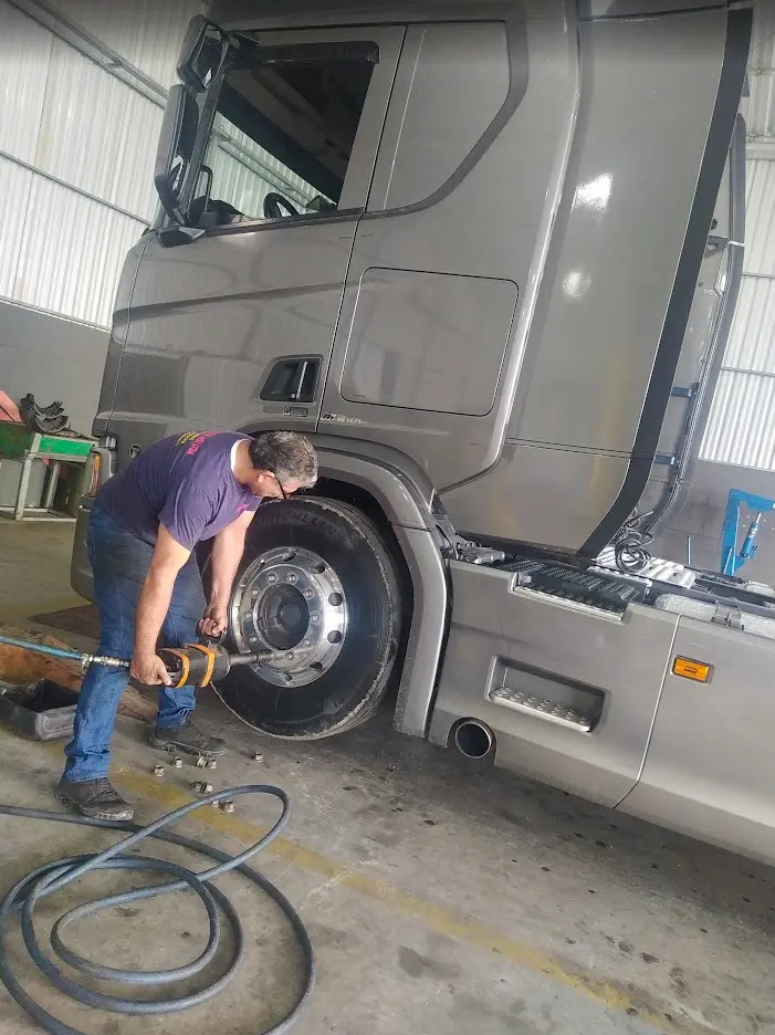 Mecânico realizando serviço na roda de caminhão
